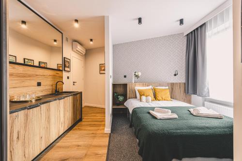 トルンにあるKlimatyczna Kamienica w Centrum Torunia - Garbary 12 by 2HomeRentのベッドと洗面台があるホテルの部屋