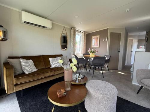 a living room with a couch and a table at TETchalet met wellness tuin in Berkhout