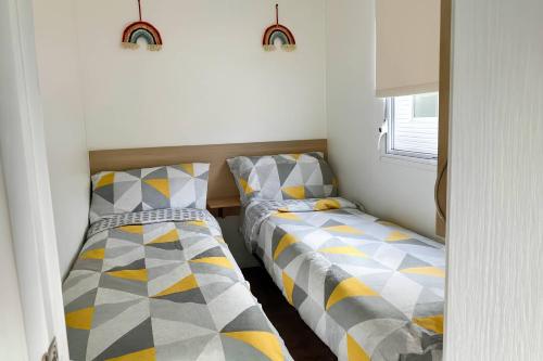 two beds sitting next to each other in a room at Golden Gate Holiday Centre - Holiday Accommodation 19058 in Kinmel Bay