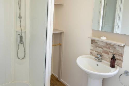 a bathroom with a sink and a shower at Golden Gate Holiday Centre - Holiday Accommodation 19058 in Kinmel Bay