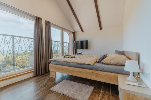 a bedroom with a bed and a large window at Marmor Collis by Winery Glavica in Gornja Gračenica