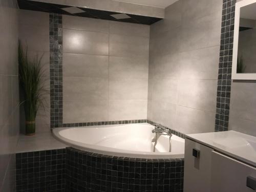 ein Badezimmer mit Badewanne und Waschbecken in der Unterkunft Chaleureuse Maison de Montagne in Garin