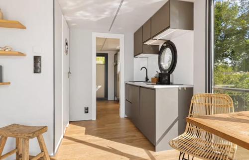 a kitchen with a table and a clock on the counter at Houseboat with lake view Tango in Haren