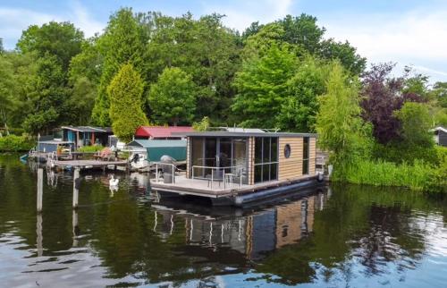 a house on a dock on a body of water at Houseboat with lake view Tango in Haren