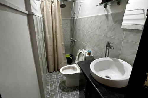 une salle de bain avec un lavabo et des toilettes dans l'établissement Casa Talisay Sleeps 6 with Garage, à Talisay