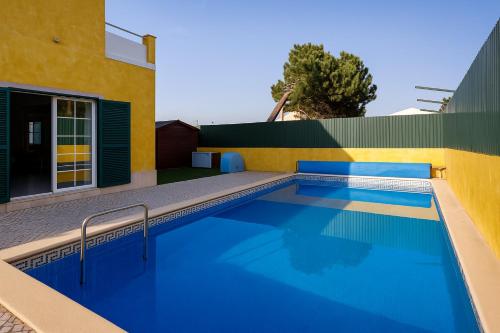 a swimming pool in front of a house at Sunny Villa in Lagoa de Albufeira - private pool by Lisbeyond in Sesimbra