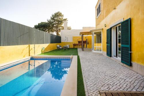 a house with a swimming pool next to a building at Sunny Villa in Lagoa de Albufeira - private pool by Lisbeyond in Sesimbra