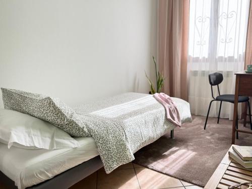 a bedroom with a bed with a table and a chair at ROSMARINO - Comodità e tranquillità con Giardino e Parcheggio in Imperia