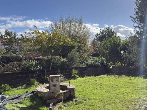 a garden with a stone fountain in the grass at Studio neuf - entrée indépendante - sans cuisine in Nantes