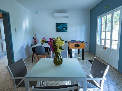 Un comedor con una mesa con un jarrón de flores encima. en Windmill Hostel, en San Julián