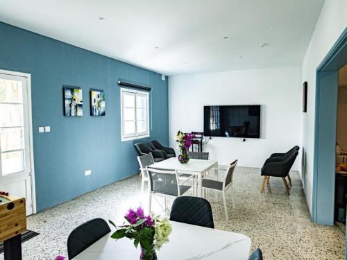 sala de estar con paredes azules, mesa y sillas en Windmill Hostel, en San Julián