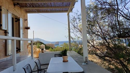 a table on the porch of a house with a view at MYRTIA , Traditional Kimolos house in Kimolos