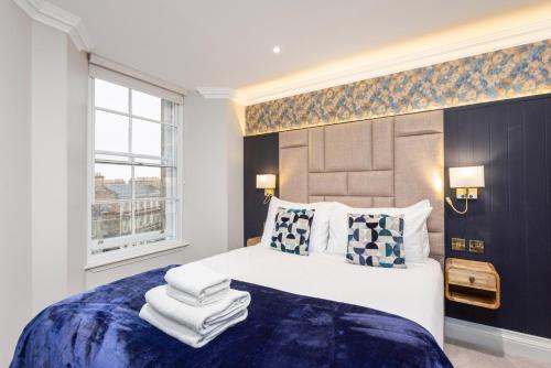 a bedroom with a large bed with a blue blanket at Central Edinburgh Prime Luxury in Edinburgh