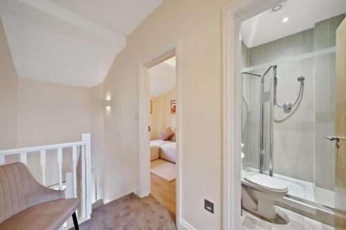 a bathroom with a toilet and a walk in shower at Beautiful Victorian Townhouse in London