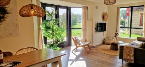 a living room with a dining table and a living room with a view at Lakeview 'Rotorua' 4-6 pers by Kawatea Cottages in Ewijk
