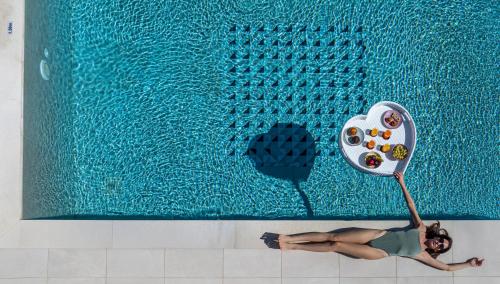 a woman laying on the floor next to a swimming pool at Villa Arancia in Pigi