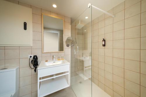 a bathroom with a sink and a glass shower at Cabot Cala Ferrera in Cala d´Or