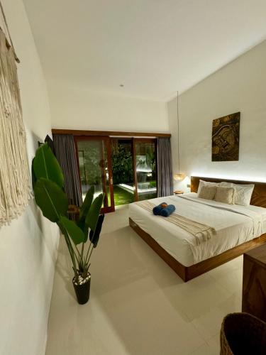 a bedroom with a bed and a potted plant at Villa Licia - Seseh area in Balian
