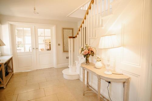 Un pasillo con una mesa con un jarrón de flores. en Lambourne House By Birch Stays, en Chirk