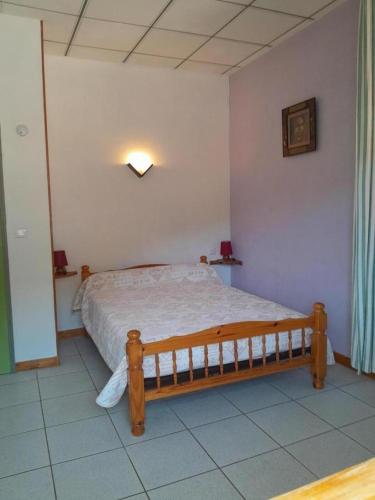 a bedroom with a wooden bed in a room at L'amandier à blajoux in Montbrun