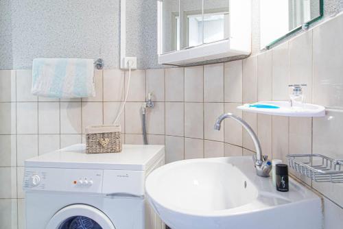 a bathroom with a washing machine and a sink at L'amandier à blajoux in Montbrun