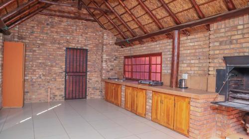 - une cuisine avec un mur en briques et un four dans l'établissement The N1 Farm Place, à Pretoria