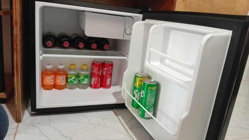 um frigorífico aberto cheio de bebidas e refrigerantes em GJE's LODGE AND GUEST HOUSE em Moalboal