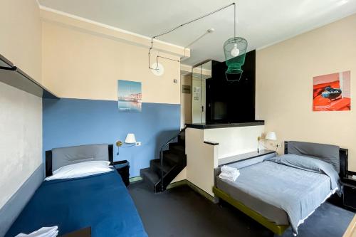 um quarto com duas camas e uma parede azul em Ostello Bello Genova em Génova