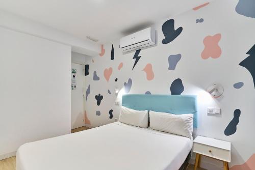 a bedroom with a bed and a wall with butterflies at Hostal Carmen by gaiarooms in Salamanca