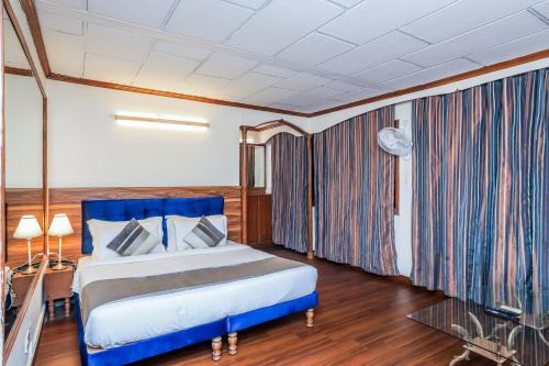 a bedroom with a blue bed in a room at asar CP Outer Circle by Orion Hotels in New Delhi