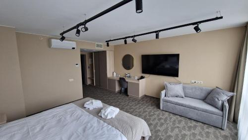 a hotel room with a bed and a couch at Suncity Hotel & SPA in Šiauliai