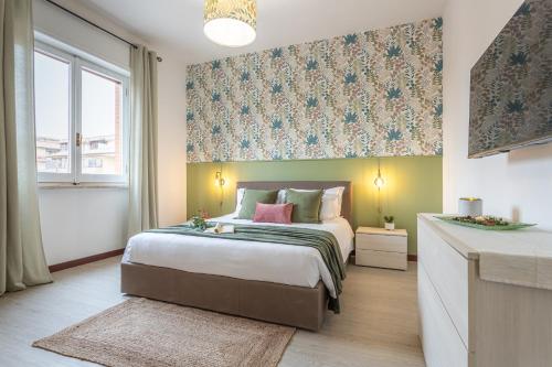 een slaapkamer met een groot bed en een raam bij Posidonia - Free Parking & Netflix - 200m to Beach in Fiumicino