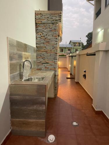 a kitchen with a sink and a brick wall at Jupiter Villa 1 and 2 in Afienya