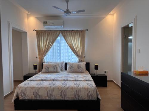 a bedroom with a bed with two pillows and a window at Jupiter Villa 1 and 2 in Afienya