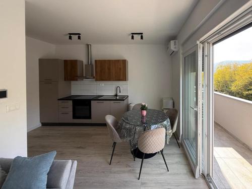 a dining room with a table and chairs and a kitchen at Apartment Mark - Old Town of Sinj view, parking in Sinj