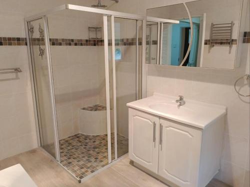 a white bathroom with a shower and a sink at Pioneer Guest House in Kloof