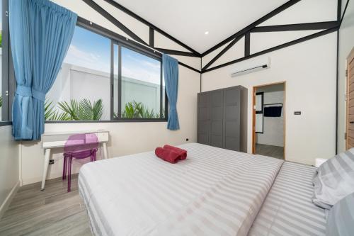 une chambre avec un grand lit blanc et une fenêtre dans l'établissement NEW! Sleek Design Oxygen Pool Villa 3 BR - Sunset Garden 14, à Ban Saiyuan (1)