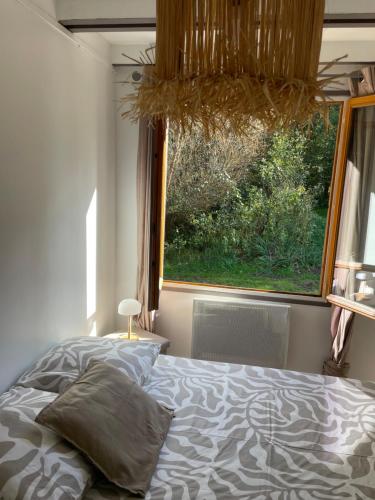a bedroom with a bed and a large window at L'armorique in Saint Die