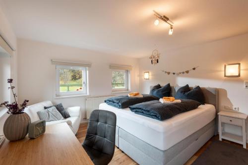 een slaapkamer met een groot bed en een bank bij Haus Gaberhel in Ellmau