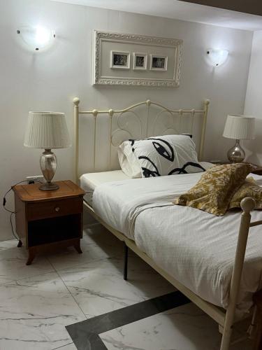 - une chambre avec un lit et une table avec deux lampes dans l'établissement Valletta apartment, à La Valette