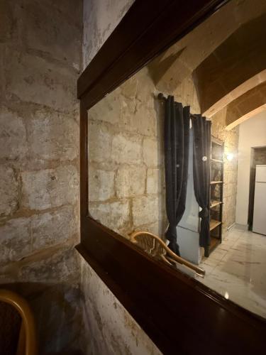 a mirror on the wall of a room with curtains at Valletta apartment in Valletta