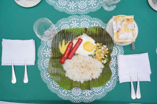 Un plato de comida con arroz y un huevo y salchicha. en Yahweh's Spring Retreat and Resort, en Calambá
