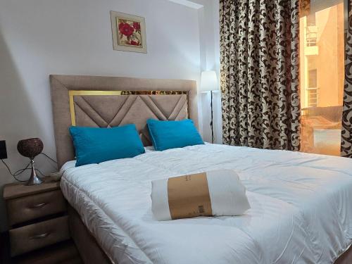 a bedroom with a large bed with blue pillows at Le Casablanca in Maarif