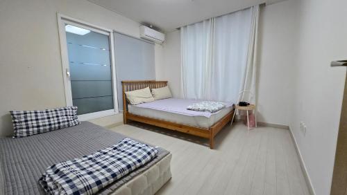 a small bedroom with a bed and a window at Rare House 4 in Incheon