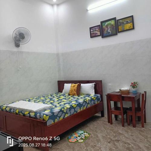 a small bedroom with a bed and a table at Thanh Phước Hotel in Ấp Thanh Ðông