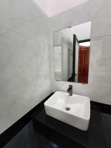 a bathroom with a white sink and a mirror at Thanh Phước Hotel in Ấp Thanh Ðông
