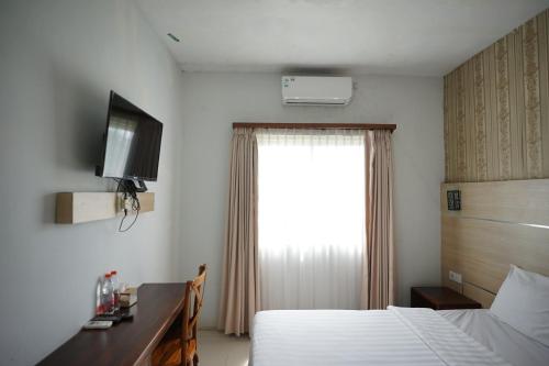 a hotel room with a bed and a window at Vinn Villa, Coffee & Resto in Bugel