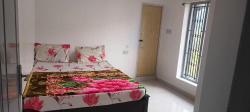 - une chambre avec un lit doté d'un couvre-lit floral et d'une fenêtre dans l'établissement December Holiday inn 2BHK House, à Kodaikānāl