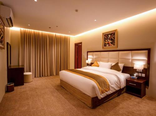 a bedroom with a large bed in a hotel room at فندق قمة البستان in Quai