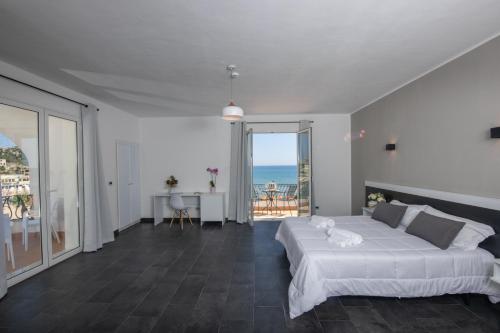 a bedroom with a bed and a view of the ocean at Hotel Baia D'oro in Licata